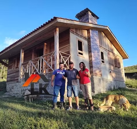 Família reunida na frente de sua nova casa de eucalipto